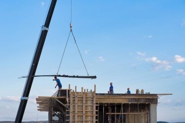 Otomatik itişli vinç inşa edilmiş bir apartmanda inşaat malzemelerini boşaltıyor.