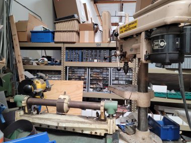 Dağınık tezgahları ve rafları olan bir fabrikanın içi.