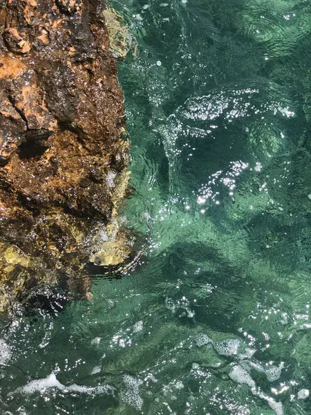 晴れた日の海の波と岩場の海岸のトップビュー — ストック写真