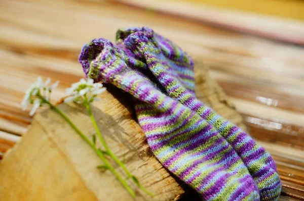 木片に編んだ靴下と花のペアのクローズアップショット — ストック写真