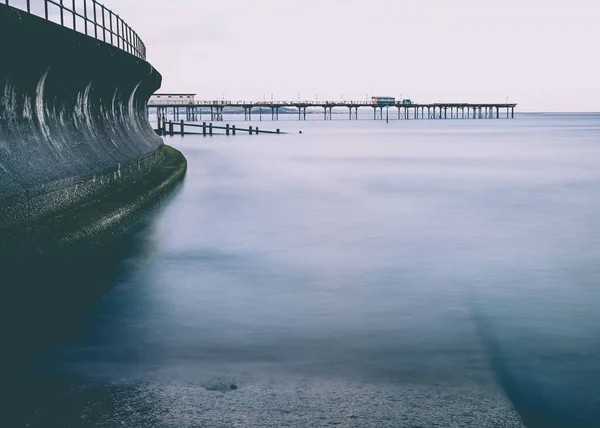 Ondas Batendo Contra Parede Mar Com Grand Pier Fundo — Fotografia de Stock