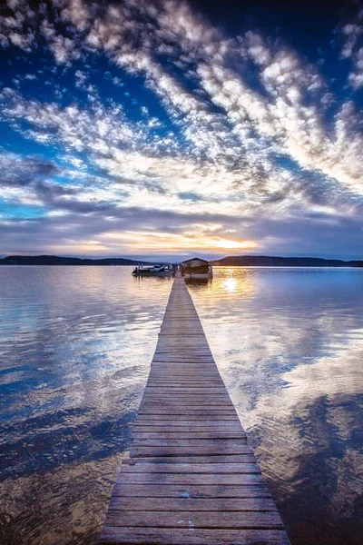 Eine Vertikale Aufnahme Eines Holzstegs Mit Wolkenverhangenem Himmel Auf Einem — Stockfoto