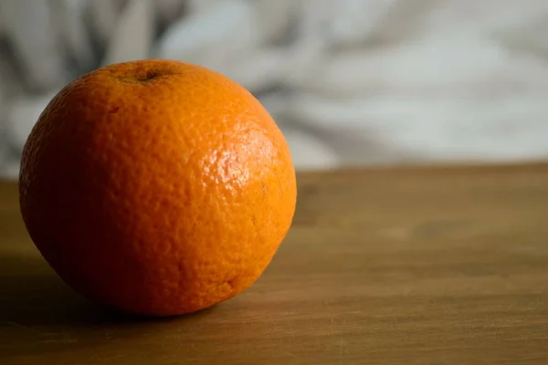 Eine Nahaufnahme Einer Orange Auf Dem Braunen Holztisch — Stockfoto