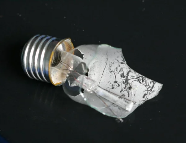 A closeup shot of a broken lamp on a black surface