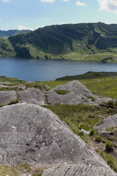 緑と岩場の丘の真ん中にある小さな湖の美しい景色の垂直ショット アイルランド — ストック写真