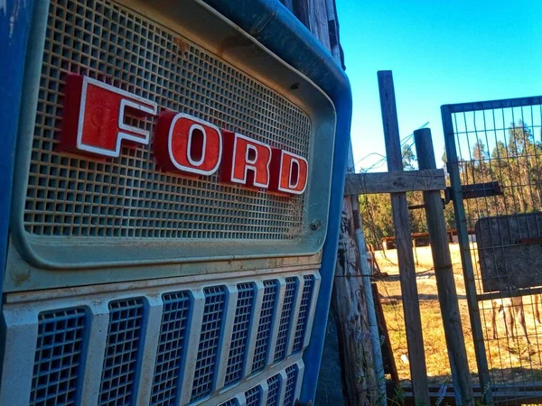 Detailní Záběr Červeného Loga Fordu Starém Polním Traktoru Vedle Plotu — Stock fotografie