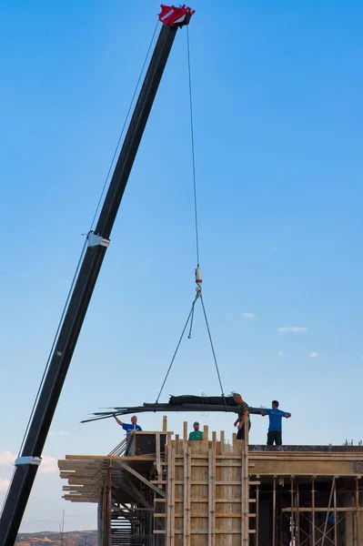 Les Travailleurs Construction Déchargent Les Matériaux Construction Une Grue — Photo