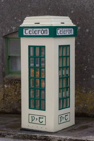 イギリスのアイルランドの通りにある白と緑の電話機のブースの垂直ショット — ストック写真