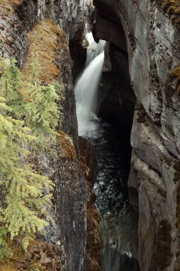 Kayalık tepelerde akan bir şelalenin uzun pozlu görüntüsü.