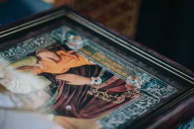 Kilisedeki dini bir ikon resmine yakın plan bir nikah yüzüğü.