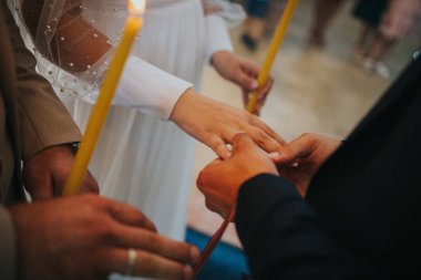 Rahip nikah töreninde gelin ve damadın parmağına alyansları takıyor.