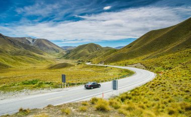 Lindis Geçidi Yeni Zelanda 'daki dağlarda siyah bir arabanın güzel manzarası.