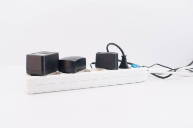 Elektrik kablosu ve şarj aletleri kopyalama alanı olan beyaz bir masada.