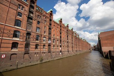 Speicherstadt, Hamburg, Almanya 'da bulutlu bir günde, kırmızı tuğlalı binalar arasında bir kanal