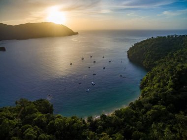 Yatlar Karayipler 'de demirliyor. Sahilde ve günbatımında arka planda. Bu bölge UNESCO 'nun Kuzeydoğu Tobago Man ve Biyosfer rezervinin bir parçasıdır.