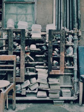 Paslı raflardaki eski plastik kapların dikey görüntüsü.