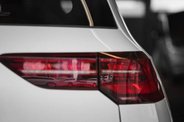 Park yerindeki lüks beyaz arabaların arka lambalarının yakın çekimi.