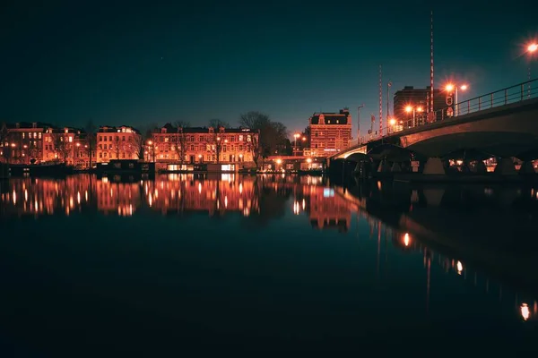 Härlig Utsikt Över Bro Flod Med Byggnader Bakgrunden Amsterdam Natten — Stockfoto