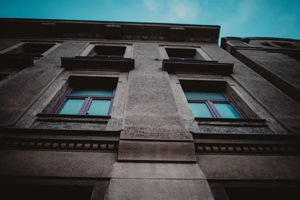 Pencereleri Mavi Gökyüzünün Arka Planı Olan Kahverengi Bir Binanın Alçak — Stok fotoğraf