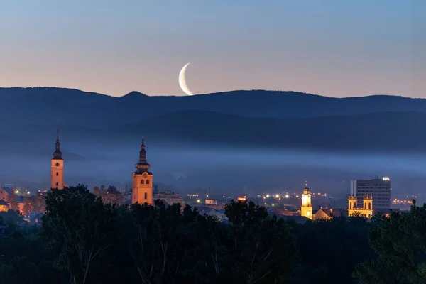 Evening Cityscape Banska Bystrica Slovakia Crescent Moon Hiding Mountain Silhouettes — Stock Photo, Image