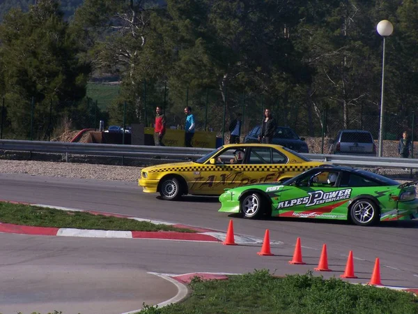 2台の黄色と緑のスポーツカーがパドックに立っている — ストック写真