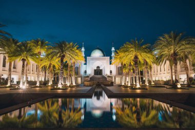 Al Buhari Camii 'nin nefes kesici manzarası geceleri suya yansıyan palmiyelerle çevrili.