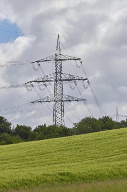 Yeşil bir alan üzerindeki güç nakil altyapısının dikey görüntüsü.