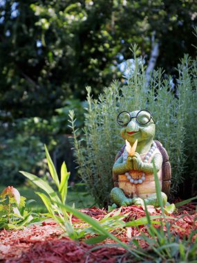 Bahçedeki küçük bir kil kaplumbağanın dikey çekimi.