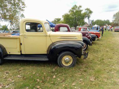 Old cream and black utility Ford pickup truck 1942 - 1947 in the countryside. Side view. Nature grass trees. Classic car show. Copyspace