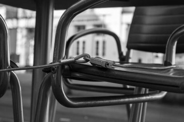 Çelik bir kablo ve metal yan parçaları ve koltukları birbirine bağlayan bir kilit.