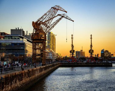 Puerto Madero, Buenos Aires 'te gün batımında deniz üzerinde vinç yüklemek için güzel bir çekim.