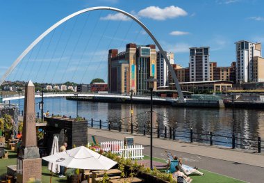 View of the Newcastle upon Tyne, UK quayside including the Gateshead Millennium Bridge and BALTIC art gallery across the River Tyne. clipart