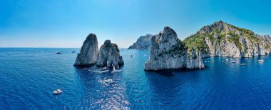 Açık gökyüzü arka planında güneşli havada uçurumların olduğu mavi bir deniz manzarası.