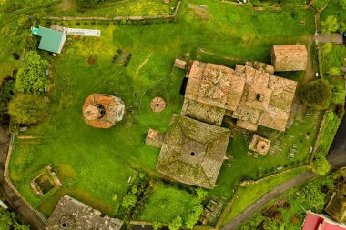 Ermenistan 'daki evlerle dolu yeşil bir tepenin üstündeki Haghpat manastırının hava manzarası.