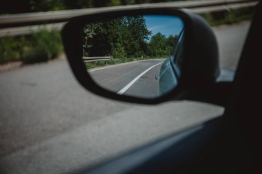 Bir asfalt yol ve ormanların gündüz vakti bir arabadan görünüşü