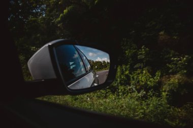 Bir asfalt yol ve ormanların gündüz vakti bir arabadan görünüşü