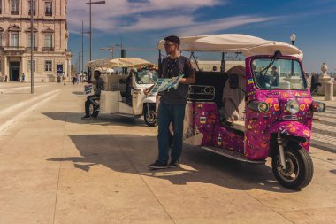 Lizbon, Portekiz, Ekim 10.2021: Pratik De Comercio Genç bir tuk tuk sürücüsü turistleri bekliyordu.