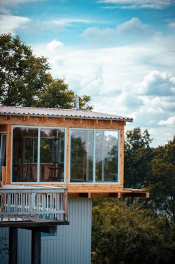 Güzel cam duvarlı bir ev Ormana ve bulutlu bir güne karşı