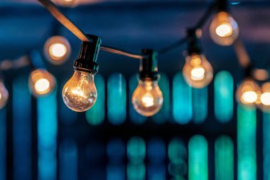 Barda asılı duran küçük ampullerin yakın çekimi.