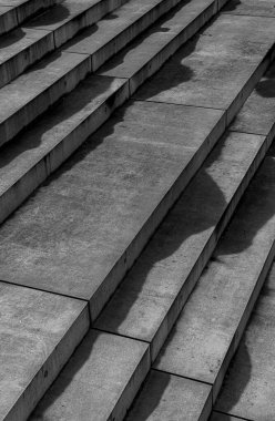 Üzerinde gölgeler olan taştan merdivenlerin dikey gri tonlarında görüntüsü.