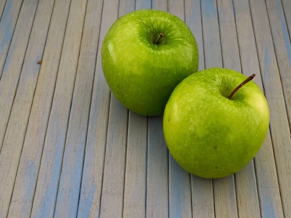 Detailní Záběr Dvou Zelených Jablek Modrém Dřevěném Stole — Stock fotografie