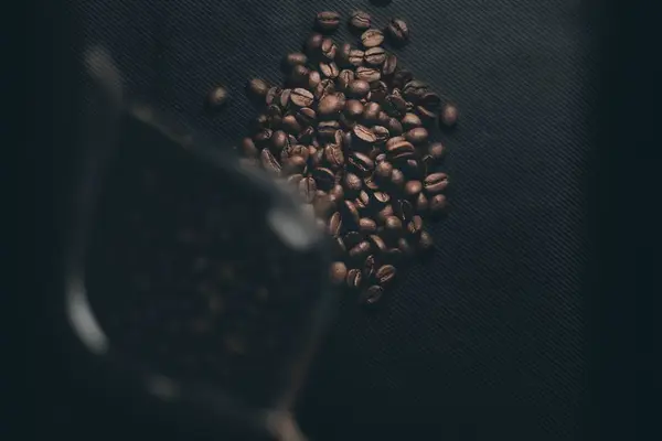 Egy Halom Kávébab Egy Kávézsák Mellett Egy Fekete Asztalon Dinamikus — Stock Fotó