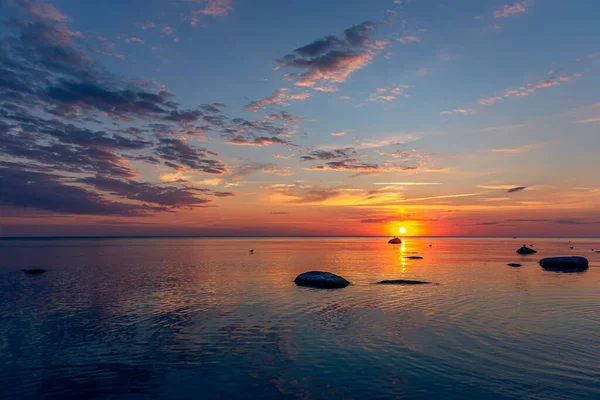 夕暮れ時の石のシルエットがカラフルな海の景色 — ストック写真