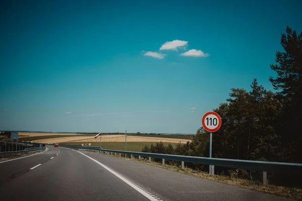 Ein Ovales Tempolimit Schild Der Nähe Einer Leeren Autobahn Mit — Stockfoto