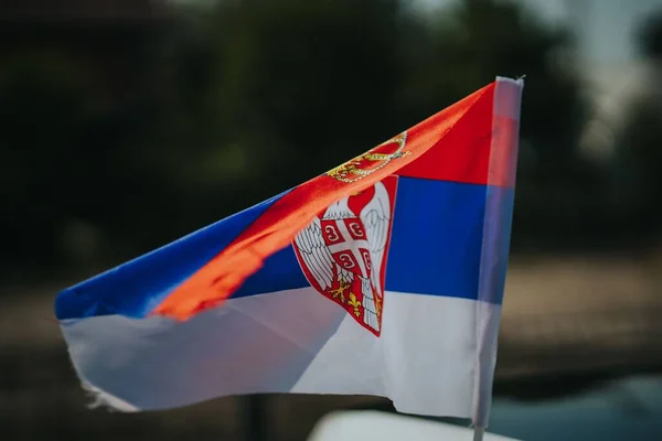 A selective focus shot of the Serbian flag waving in the wind