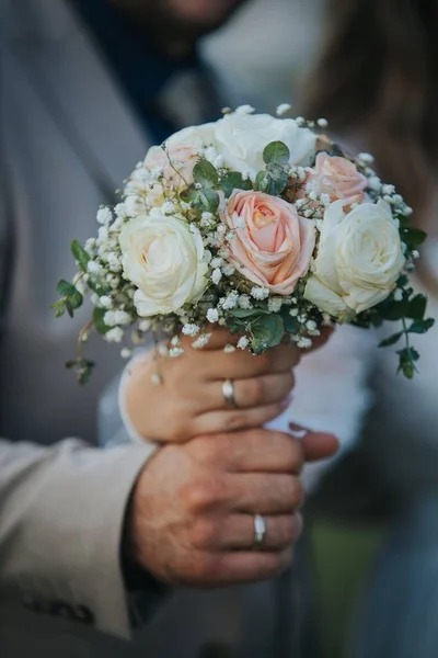 結婚指輪と手で開催されたバラのブライダル花束の垂直閉鎖 — ストック写真
