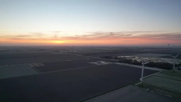 一个高角形的麦田和风力涡轮机拍摄 金色的太阳落在地平线上 — 图库照片