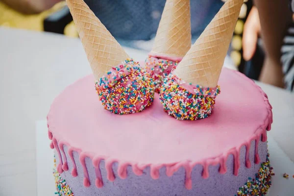 ピンクと白のケーキの上にアイスクリームコーン — ストック写真
