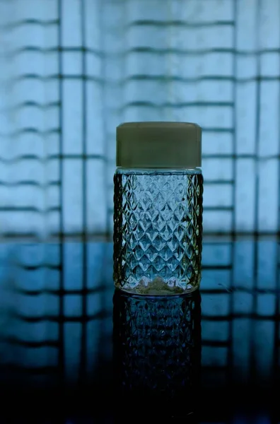 窓の前のテーブルの上の装飾的な水のボトル — ストック写真