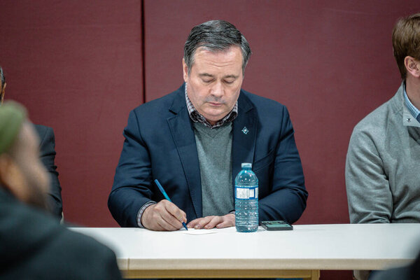 Jason Kenney taking notes at a community town hall even